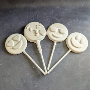 White chocolate smiley face lollipops handcrafted by Chocolates by Design.