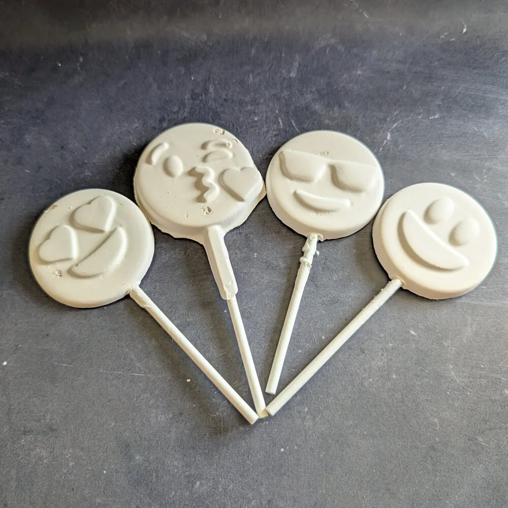 White chocolate smiley face lollipops handcrafted by Chocolates by Design.
