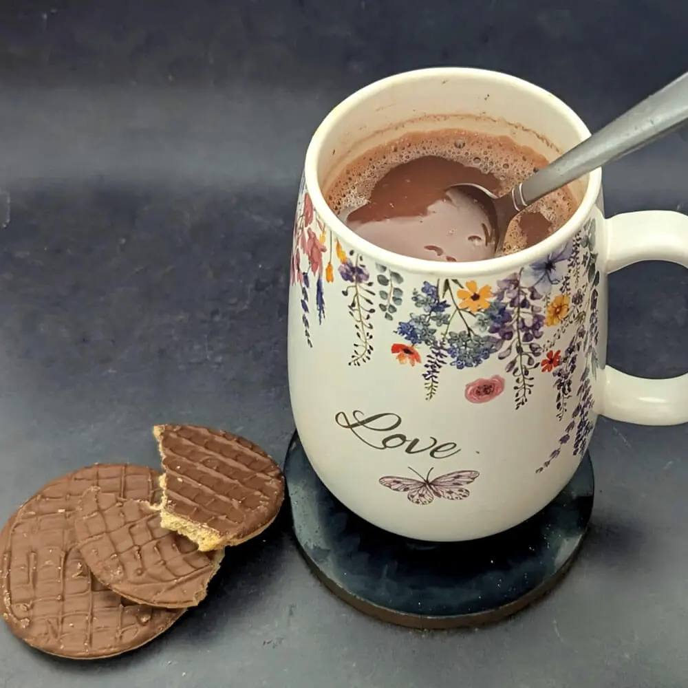 Mug of rich hot chocolate with biscuits made by Chocolates by Design.